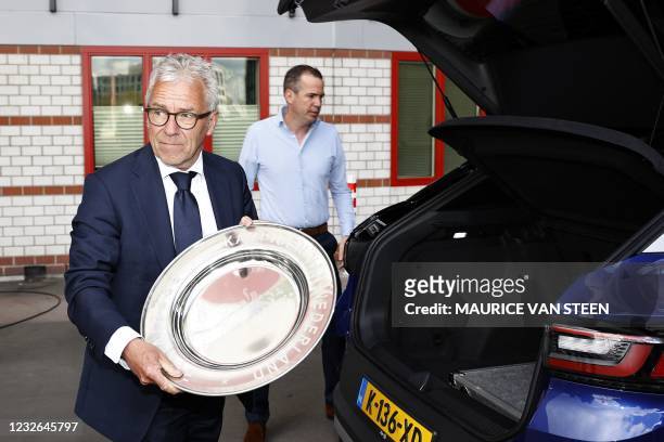 General director Eric Gudde poses with the Dutch Eredivisie trophy dish prior to the Dutch Eredivisie football match between Ajax Amsterdam and FC...