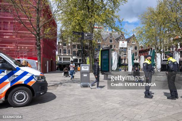 Dutch police officers stand guard the Leidseplein as Mayor Femke Halsema has issued an emergency ordinance the surrounding areas to keep the terraces...