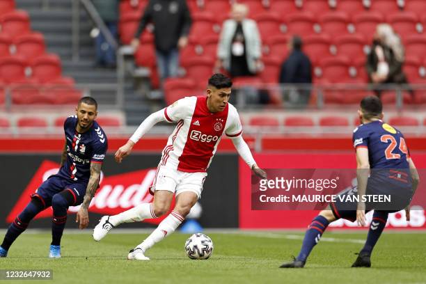 Ajax's Mexican defender Edson Alvare fights for the ball against FC Emmen's Peruvian midfielder Sergio Pena and teammate French midfielder Lucas...