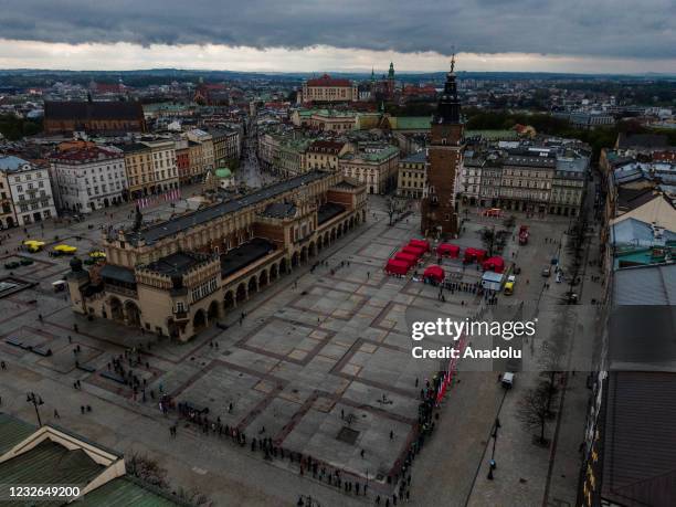 An aerial view of people line up to receive a Johnson & Johnson covid-19 vaccine at Krakow's UNESCO listed Main Square on May 02, 2021 in Krakow,...