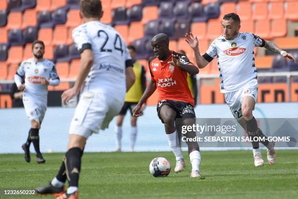 Lorient's French forward Yoane Wissa is challenged by Angers' French-Portuguese midfielder Mathias Pereira Lage during the French L1 football match...