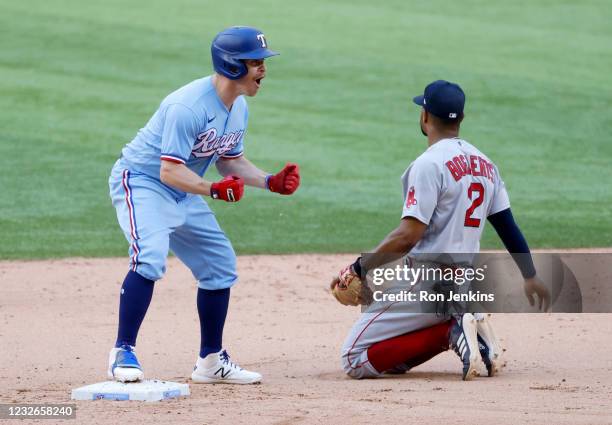 Brock Holt of the Texas Rangers reacts after hitting a two-run go ahead double as Xander Bogaerts of the Boston Red Sox looks away during the eighth...