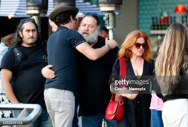 Russell Crowe hugs Sacha Baron Cohan as Isla Fisher leaves lunch and Ross Noble looks on at China Doll in Woolloomooloo, Sydney, New South Wales.