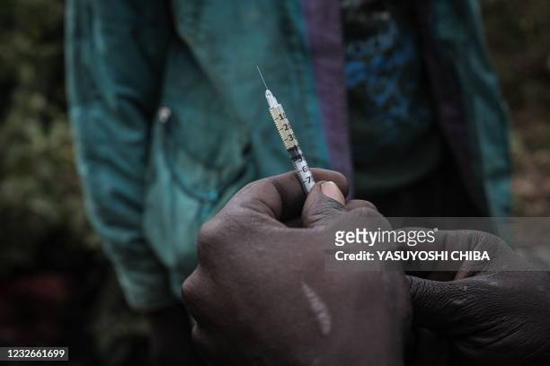 Year-old male drug addict holds a syringe with heroin at Kawangware slum in Nairobi, Kenya, on January 22, 2021. - Once just a passing stop on the...