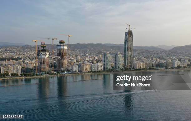The boat sails against the backdrop of skyscrapers under construction on the embankment of the Mediterranean port of Limassol. Cyprus, Monday, May 3,...