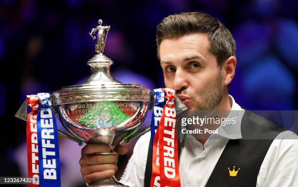 Mark Selby of England celebrates with the trophy following his victory during the Final between Shaun Murphy and Mark Selby on day seventeen of the...