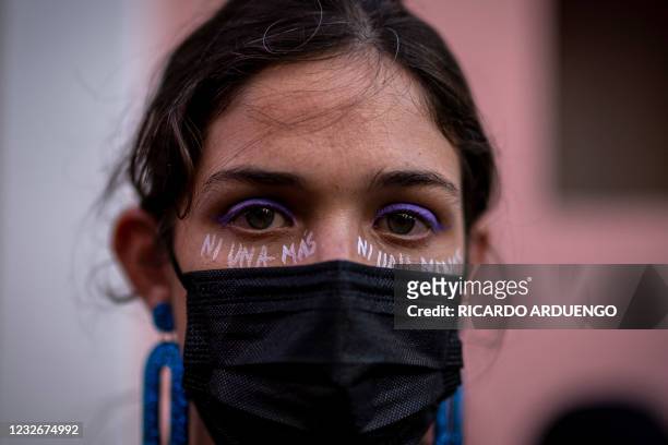 Woman painted the words "Not One More" on her face as she participates in a demonstration against sexual violence in front of the governor's mansion...