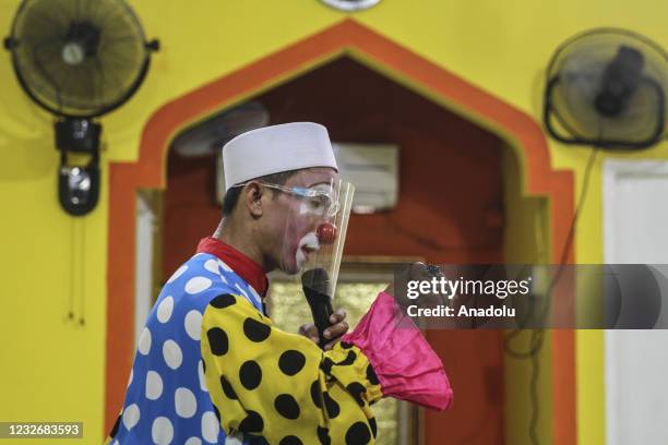 Yahya Edward Hendrawan wears a clown costume teaches the Quran at the Darussalam An-Nur Foundation in Tangerang, Banten province on April 29, 2021....