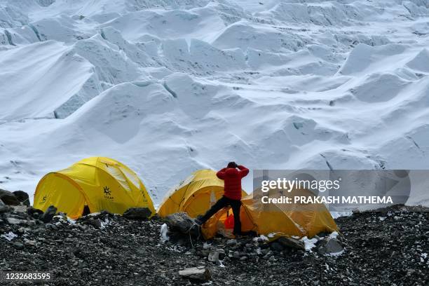 In this photograph taken on May 2, 2021 an expedition team member looks at the Khumbu icefall with binoculars from the Everest base camp, in the...
