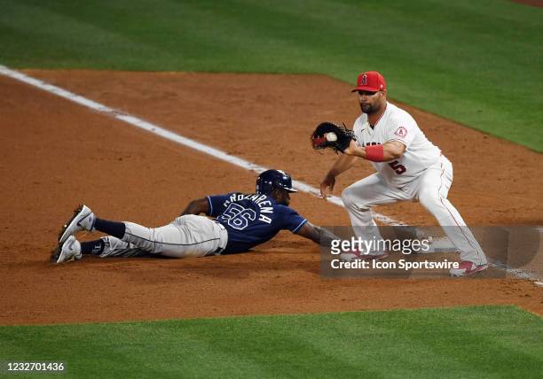 Tampa Bay Rays outfielder Randy Arozarena dives back to first base safely before Los Angeles Angels first baseman Albert Pujols can apply a tag...