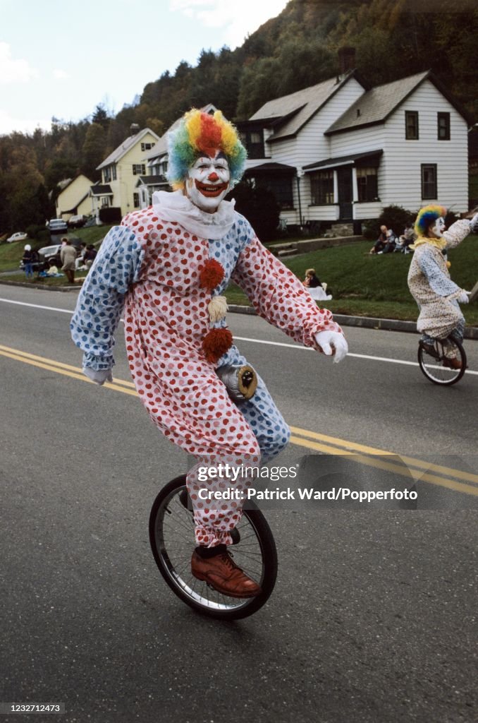 Fall Parade Costumed and face-painted clowns riding unicycles in the Fall Foliage ...