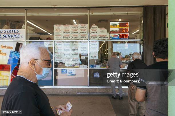 People wait in line to buy lottery tickets in Miami, Florida, U.S., on Wednesday, April 14, 2021. The U.S. Economy is on a multi-speed track as...