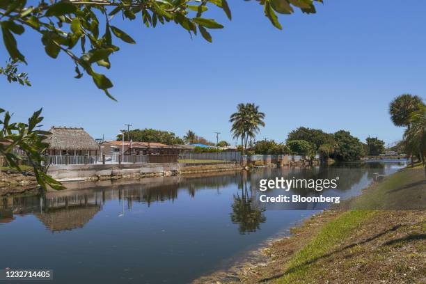 Homes next to a water inlet in Hialeah, Florida, U.S., on Tuesday, April 13, 2021. The U.S. Economy is on a multi-speed track as minorities in some...