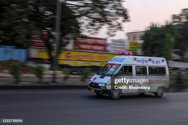 An ambulance travels along an empty road during lockdown restrictions imposed by the state government in Pune, Maharashtra, India, on Wednesday, May...