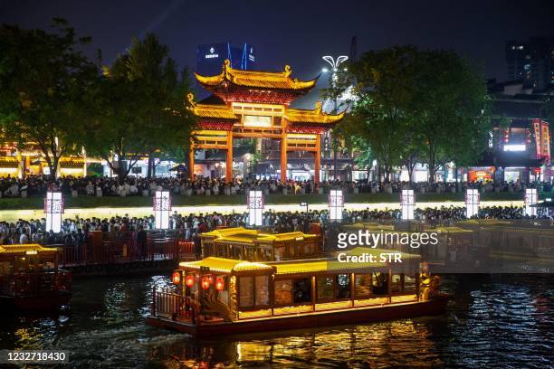 This photo taken on May 4, 2021 shows people riding boats as they visiting Fuzimiao, also called Confucian Temple, in Nanjing, in China's eastern...