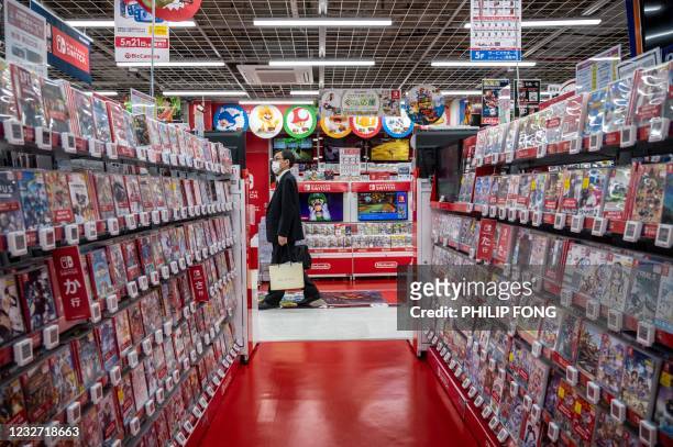 Customer walks past the self of Nintendo video games and accessories at the gaming section of a shop in Tokyo on May 6, 2021.