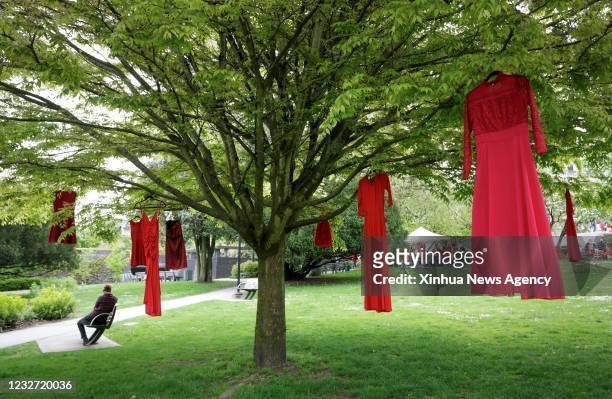 May 5, 2021 -- Red dresses are seen hanging on trees to commemorate missing and murdered indigenous women and girls outside the City Hall in...