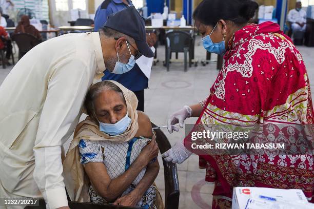 Health worker incoluates a woman with a dose of the Sinopharm Covid-19 coronavirus vaccine at a vaccination centre in Karachi on May 6, 2021.