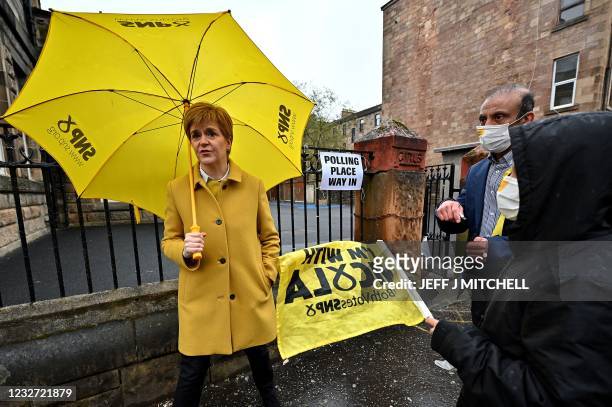 Scotland's First Minister and leader of the Scottish National Party , Nicola Sturgeon gestures as she meets voters at Annette Street school polling...