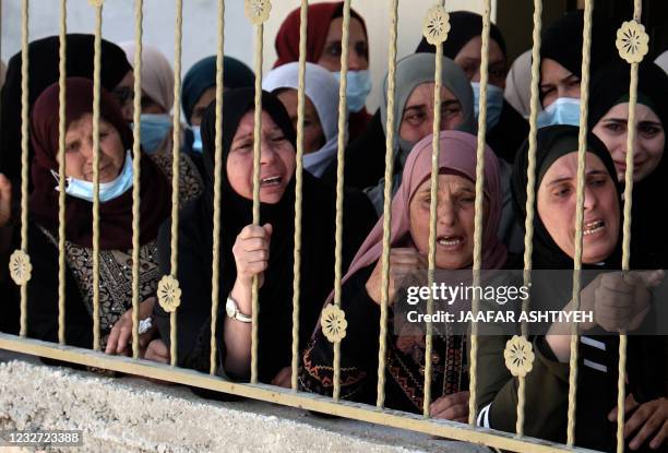 Women cry as the body of 16-year-old Palestinian Said Youssef Muhammad Oudeh is carried out of his family home, to begin his funeral procession in...