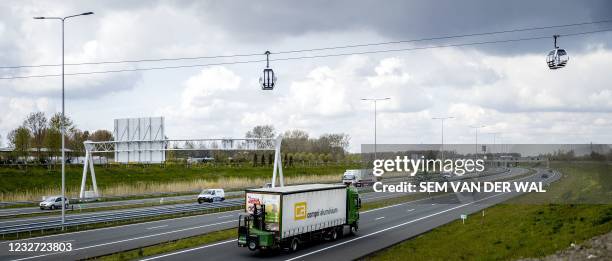 Gondolas hang on the 850 meter long cable, which will transport visitors over the A6 highway to the Floriade 2022 horticultural exhibition center in...