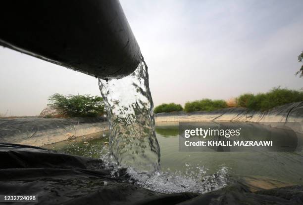 Water pours into an agricultural irrigation pool in Ghor al-Haditha, around 80km south of the Jordanian capital Amman, on April 20, 2021. Experts say...