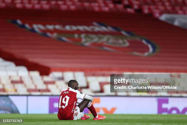 Nicolas Pepe of Arsenal sits, dejected, after their loss during the UEFA Europa League Semi-final Second Leg match between Arsenal and Villareal CF...