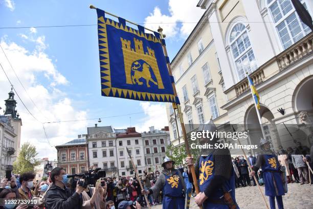 Reconstructor in the form of a knight of the princely era of the founding of Lviv holds a flag with the coat of arms of the city during the...
