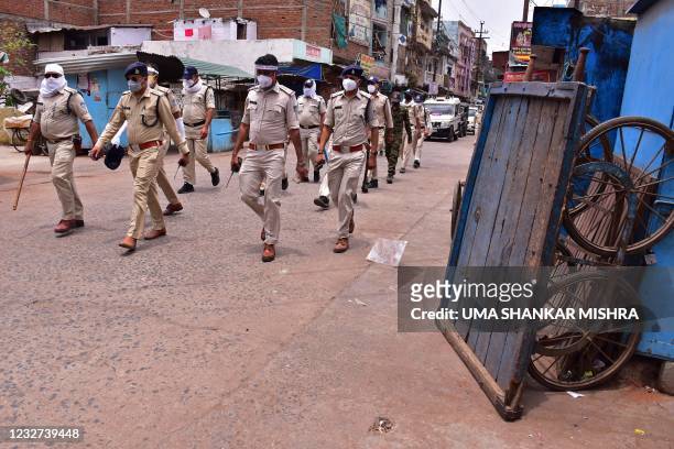 Police personnel patrol along a deserted street during restrictions imposed as a preventive measure against the spread of the Covid-19 coronavirus in...