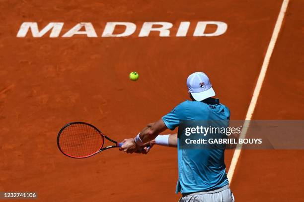 John Isner returns the ball to Austria's Dominic Thiem during their 2021 ATP Tour Madrid Open tennis tournament singles quarter-final match at the...