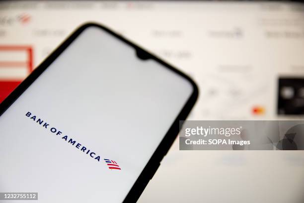 In this photo illustration a Bank of America logo seen displayed on a smartphone screen with Bank of America website in the background.