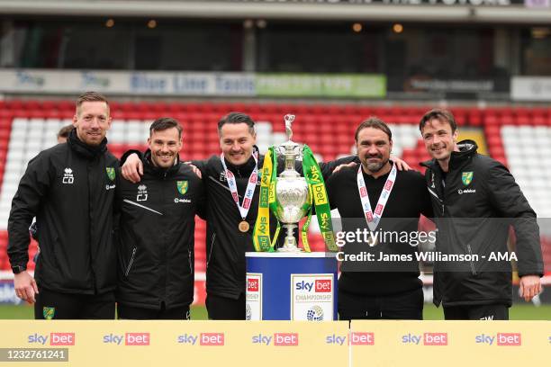 Daniel Farke the head coach / manager of Norwich City and his coaching stand celebrate with the Sky Bet Championship trophy during the Sky Bet...