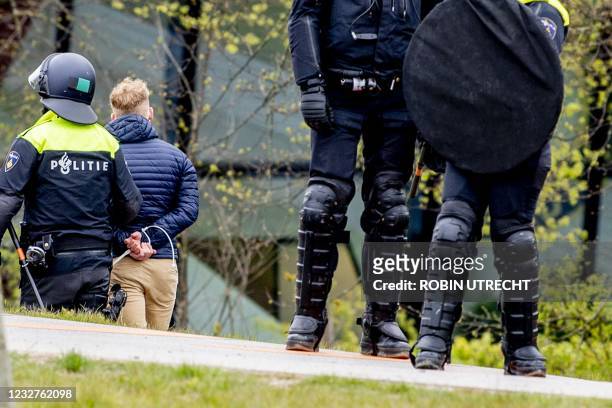 Man is arrested by police officers after Feyenoord fans threw fireworks and stones at the police in Rotterdam, on May 8 following a supporters'...