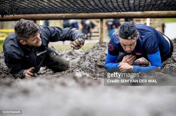 People compete in the "Mud masters" Fieldlab trial event Mud Masters in Amsterdam, on May 8, 2021. - The Netherlands is currently under a national...