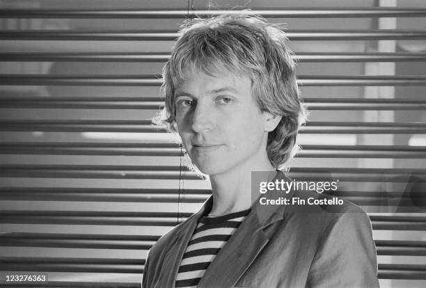 Andy Summers, guitarist with British rock band The Police poses in front of a window covered by a venetian blind in a studio portrait, United...