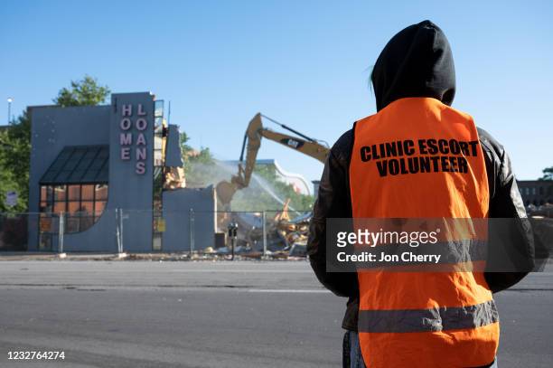 An adjacent building is demolished as a volunteer clinic escort stands in front of EMW Women's Surgical Center, an abortion clinic, on May 8, 2021 in...