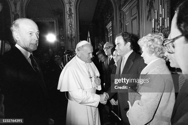 Pope John Paul II flanked by French President Valery Giscard d'Estaing shakes hands with Secretary General of the french Communist Party Georges...