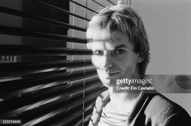 Sting, singer and bassist with British rock band The Police poses in front of a window covered by a venetian blind in a studio portrait, United...