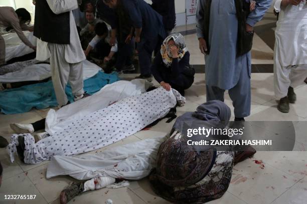 Graphic content / TOPSHOT - Family members and relatives mourn inside a hospital while sitting next to the bodies of victims who died in a blast...