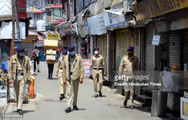 Police personnel patrol the streets of Lower Bazaar during a curfew imposed to curb the spread of coronavirus disease, on May 8, 2021 in Shimla,...