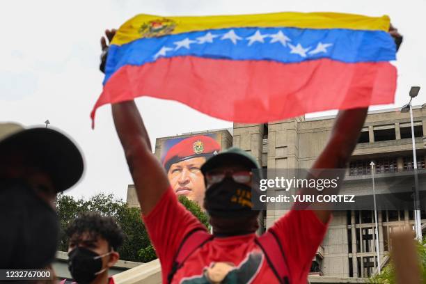 Venezuelans shout slogans and raise their fists as they participate in an act of solidarity with the Colombian people at Bolivar Avenue, in front of...