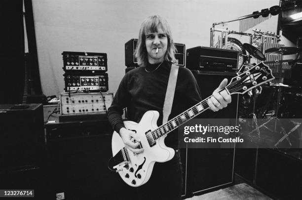 Alex Lifeson, guitarist with Canadian rock band Rush, smoking a cigarette as he plays his guitar during a soundcheck ahead of the band's gig at...