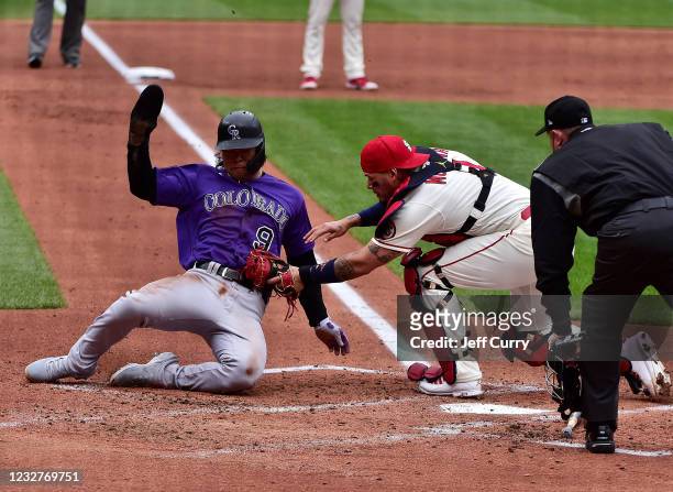 Connor Joe of the Colorado Rockies is tagged out at home by Yadier Molina of the St. Louis Cardinals during the second inning at Busch Stadium on May...