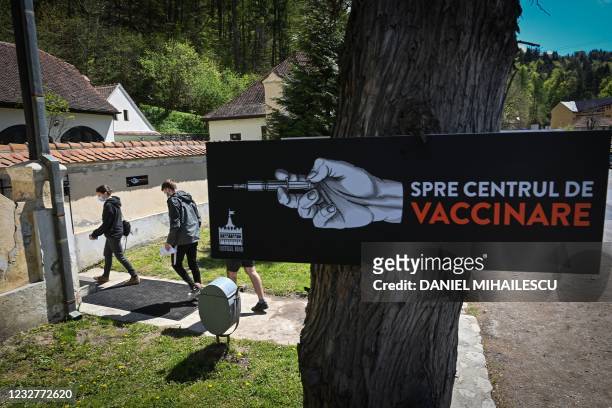 People arrive at a vaccination center during the vaccination marathon organised at the "Bran Castle" in Bran village on May 8, 2021. - Romanian...