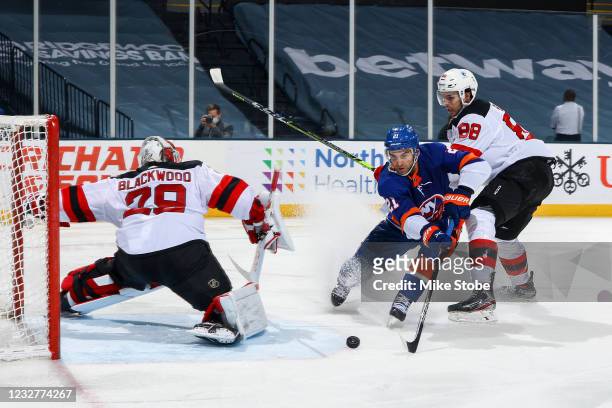 Kyle Palmieri of the New York Islanders scores a goal past Mackenzie Blackwood of the New Jersey Devils while defended by Kevin Bahl during the third...