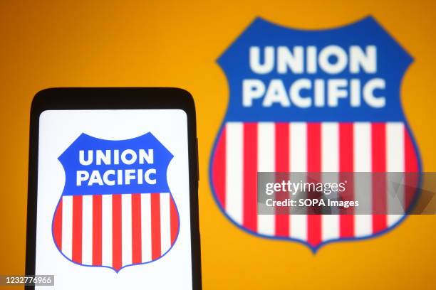 In this photo illustration, a Union Pacific logo of the US railroad company seen on a smartphone and a pc screen.