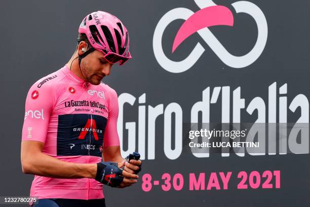 Team Ineos rider Italy's Filippo Ganna, wearing the overall leader's pink jersey, walks on the stage prior to the start of the second stage of the...