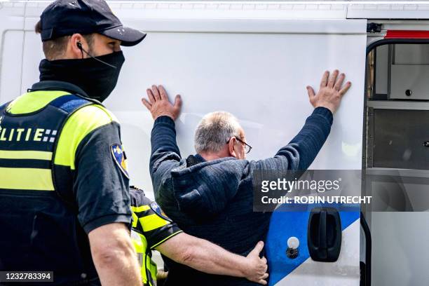 Police officers frisk a man, prior to the Eredivisie soccer match between Feyenoord and Ajax at the Feyenoord Stadium in Rotterdam on May 9, 2021. -...