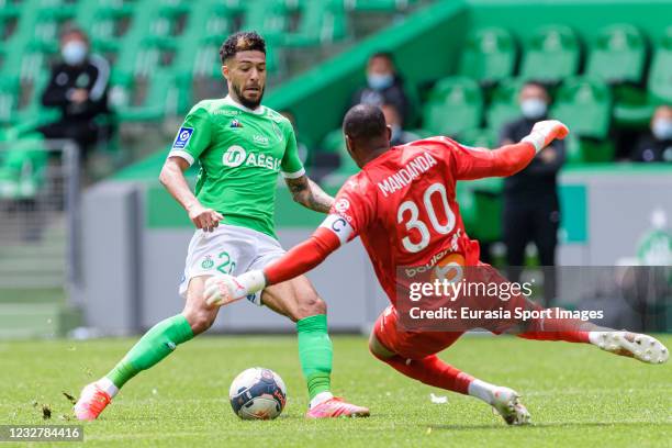 Denis Bouanga of Saint-Étienne battles for the ball with Steve Mandanda of Olympique de Marseille during the Ligue 1 match between AS Saint-Etienne...