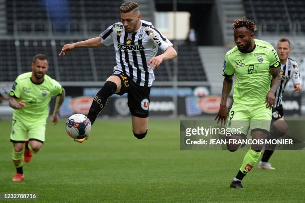Angers' Algerian forward Farid El Melali controls the ball past Dijon's Congolese defender Glody Ngonda during the French L1 football match between...